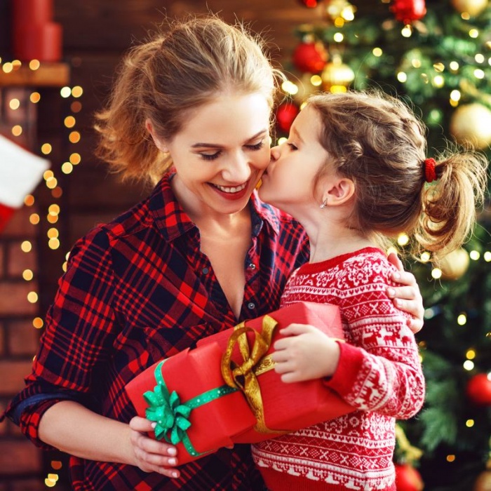 mother and daughter with Christmas gift wrapped in red with a green bow